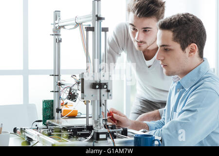 Young students in the laboratory using a 3D printer, technology and education concept Stock Photo