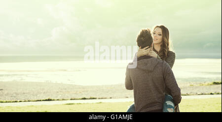 Happy young loving couple at the lake hugging in the sunlight, love and relationships concept Stock Photo
