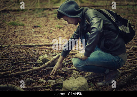 Man in the forest exploring and searching for tracks, adventure and freedom concept Stock Photo