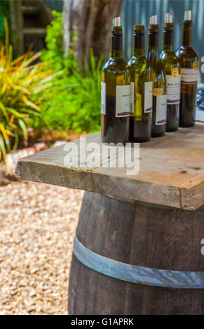 Wine bottles on barrel Winery and vineyards on Waiheke Island off Auckland, New Zealand Stock Photo