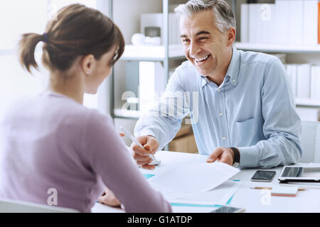 Young woman having a business meeting and signing a contract, recruitment and agreement concept Stock Photo