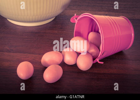 Easter eggs in a violet bucket on a wooden table Stock Photo