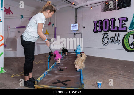 London, UK.  12 May 2016.  Junkyard Golf opens at the Old Truman Brewery, near Brick Lane in East London and will be in place until the end of August.  Three nine-hole crazy golf courses - 'FRANK' (Putt Up Or Shut Up), 'PEDRO' (Polluted Paradise), and HELGA (In Da Club) - have been created out of junk and odds and ends to give players of all skill levels a novel fun-filled experience.  Proceeds raised from sales of golfing loveheart sunglasses will go to Love Support Unite, a charity supporting children in Malawi.  Credit:  Stephen Chung / Alamy Live News Stock Photo