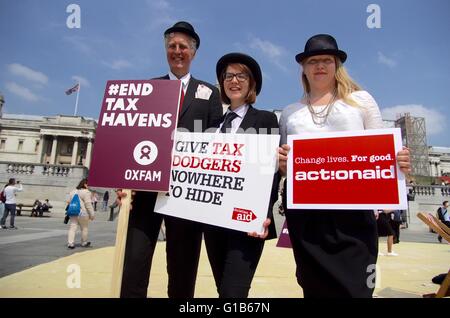 London, UK. 12th May 2016. Activists from Oxfam, Action Aid and Christian Aid make a ‘tropical tax haven’ to protest tax avoidance in Trafalgar Square, to coincide with an international Anti-Corruption Summit hosted by Prime Minister David Cameron. Credit:  Denis McWilliams/Alamy Live News