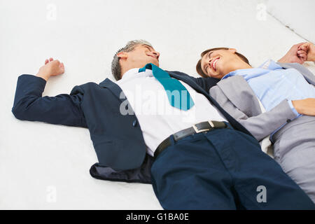 Happy business couple laying on bed in a hotel room Stock Photo