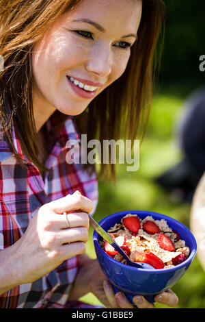Portrait of a Woman Eating Breakfast Cereals With Fruit Outside in the Garden Looking Happy and Relaxed Stock Photo