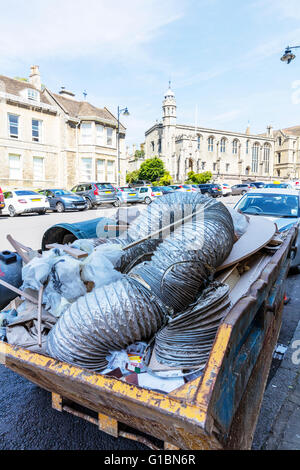 Skip full of rubbish on road builders trash filling skip hire waste management UK England English towns Stock Photo