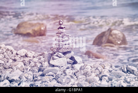 Retro toned stones on beach, harmony concept background. Stock Photo