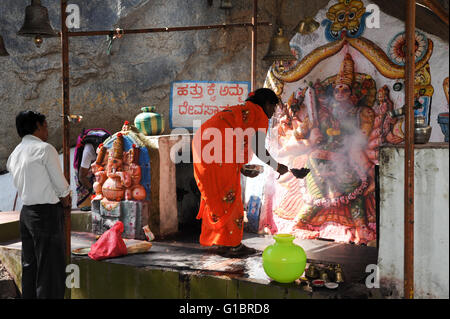 Hampi, India - 13 January 2015: Woman makes an offering at a Hindu temple at Hampi on India Stock Photo