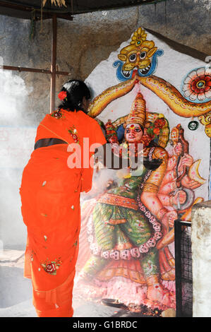 Hampi, India - 13 January 2015: Woman makes an offering at a Hindu temple at Hampi on India Stock Photo