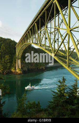 Fishing Boat passes beneath Deception Pass bridge, Deception Pass State Park, Whidbey Island, Puget Sound, Washington Stock Photo