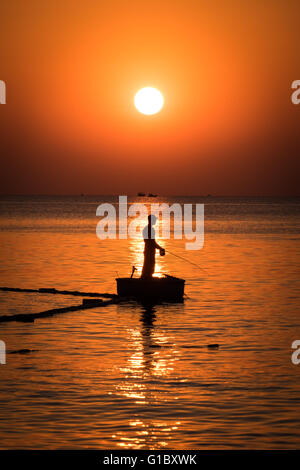 A man fishing at sunset in the resort island of Phu Quoc off the coast of Southern Vietnam Stock Photo