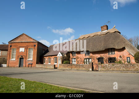 Typical English village street. Meeting hall converted to a next to a thatched property in the village of Bosham Stock Photo