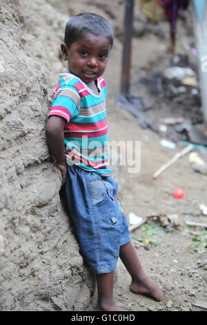 Pune, India - July 16, 2015: A poor Indian boy standing at a construction site where his parents work in India Stock Photo
