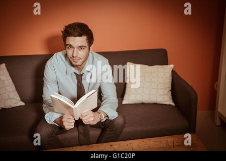 Man at home reading book Stock Photo