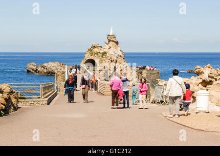 Tourists walk the bridge to la rocher de la vierge, virgin mary rock. Aquitaine, basque country, Biarritz, France. Stock Photo