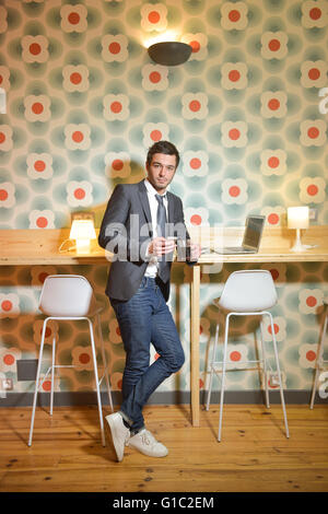 Handsome business man in restaurant drinking coffee Stock Photo