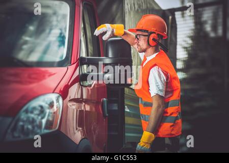 Worker and His Truck. Hard Working Men Wearing Construction Safety Accessories. Stock Photo