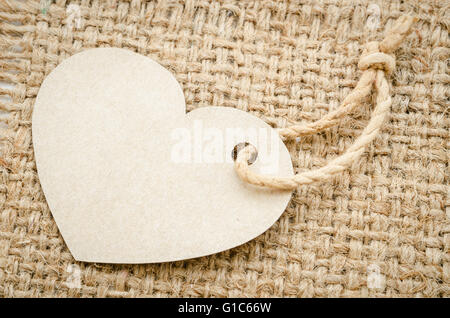 Brown paper price tags Heart shapes with brown rope on sack background. Recycled paper. background and texture. Stock Photo