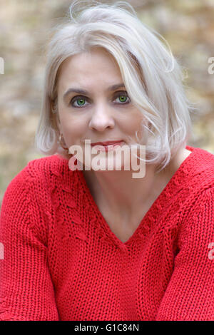 Portrait of a green-eyed blonde in the red sweater Stock Photo
