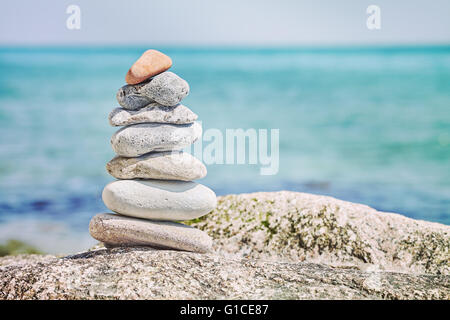 Retro toned stones on beach, harmony concept background. Stock Photo