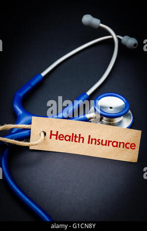 Health insurance word in paper tag with stethoscope on black background - health concept. Medical conceptual Stock Photo