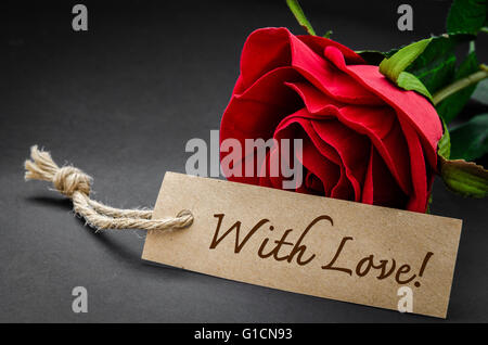 With love word on recycle brown paper with red rose on black. Stock Photo