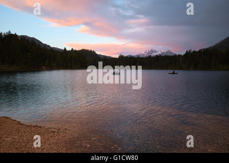 fishermen on boats on lake Hintersee at a rainy, colorful sunset, Berchtesgaden, Bavaria, Germany