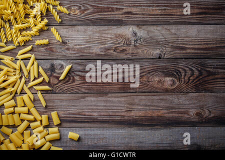 Mixed dried pasta selection on wooden background. Stock Photo