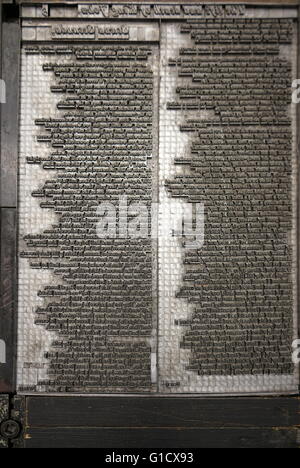 Metal plate with letters set to print a page from a reconstruction of a 16th Century printing press. Stock Photo