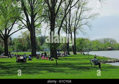 Group of people picnicking at riverside park. Stock Photo