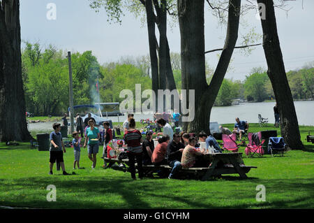 Group of people picnicking at riverside park. Stock Photo