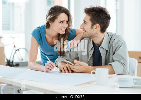 Romantic loving couple planning and designing their new house, they are staring at each other's eyes Stock Photo