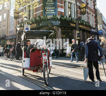 Rickshaw drivers take a rest and wait for customers outside The Palace Theatre on Cambridge Circus in  London's West End, UK Stock Photo