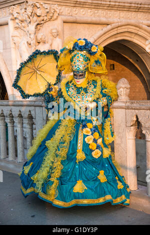 Venetian woman dressed in dramatic costume in front of the Palace of Doges during Carnival. Stock Photo