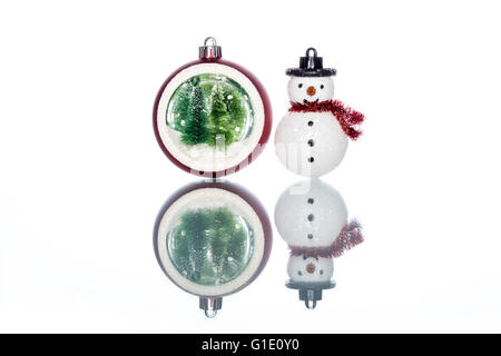 snowglobe with christmas tree inside with snowman on white Background, Reflection Stock Photo
