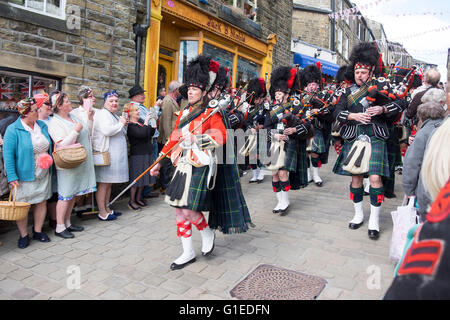 Haworth, Yorkshire, UK. 14th May, 2016. The village of haworth, west yorkshire, is transformed for the annual 1940’s weekend. A Pipe Band marches down the main street in Haworth while Re enactors look on. Credit:  Light-Phase Photography/Alamy Live News Stock Photo