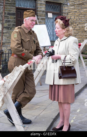 Haworth, Yorkshire, UK. 14th May, 2016. The village of haworth, west yorkshire, is transformed for the annual 1940’s weekend. A member of the home guard is talking to a local re enactor. Credit:  Light-Phase Photography/Alamy Live News Stock Photo