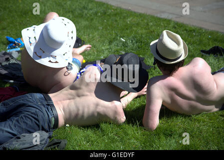 Glasgow, Scotland, UK. 14th May, 2016. Three local lads enjoy the sun ' Taps Aff'or tops off a Glasgow tradition to greet the sun. As the rest of Britain basks in cloud, tops on Stock Photo
