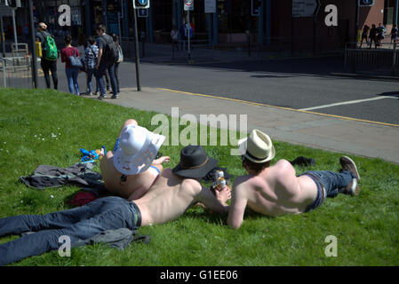 Glasgow, Scotland, UK. 14th May, 2016. Three local lads enjoy the sun ' Taps Aff'or tops off a Glasgow tradition to greet the sun. As the rest of Britain basks in cloud, tops on: Stock Photo