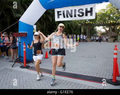 West Palm Beach, Florida, USA. 14th May, 2016. (l to r) Susan Anderson, Palm Beach Gardens and Pamela Piekkola, Stuart, cross the finish line at The Save The Tiger 5K named in honor of zookeeper Stacey Konwiser at Palm Beach Zoo on Saturday, May 14, in West Palm Beach. © Allen Eyestone/The Palm Beach Post/ZUMA Wire/Alamy Live News Stock Photo