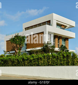 White House, L'Ametlla. Exterior view of the modern house. Partially hidden by shrubs and bushes. Stock Photo