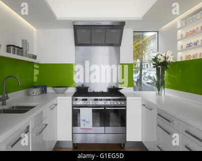 Modern Family home, Shepherds Bush, London. Kitchen with modern sleek features and stainless steel appliances. Green accents. Stock Photo
