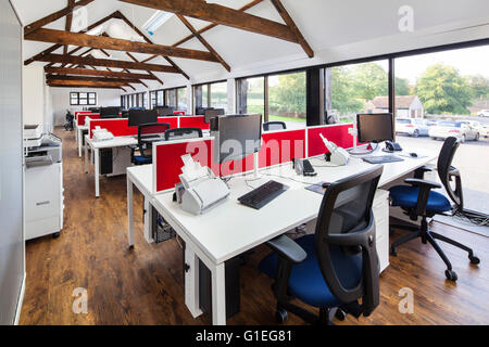 Barn Conversion into office space. Furniture by OEG Interiors. Rows of office desks with computers. Barn rafters. Stock Photo