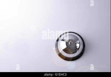 Hotel service bell on a table white glass. Concept hotel, travel, room. Top view Stock Photo