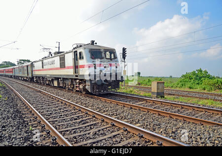 WAP-7 class 6000 Horsepower electric locomotive hauling Poorva Express on Howrah-New Delhi line, rural West Bengal, India Stock Photo