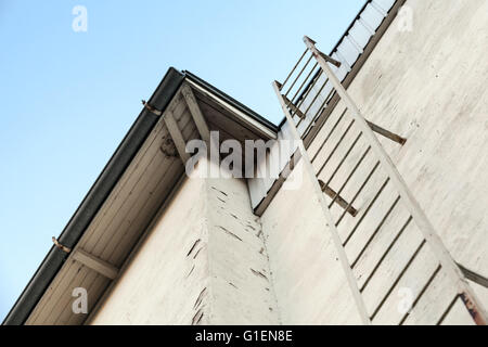 Metal rescue ladder on old white wall, selective focus Stock Photo