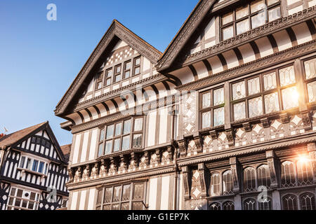 Black and white buildings in Chester, with beautiful clear blue sky and sunlight reflecting in windows, Cheshire, England, UK Stock Photo