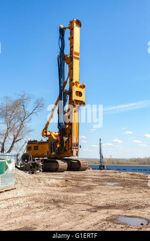 Pile driver at the construction of new Frunze bridge across the Samara river in sunny day Stock Photo