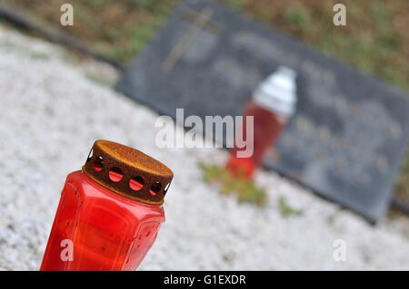 Burner and candle on tomb in churchyard Stock Photo